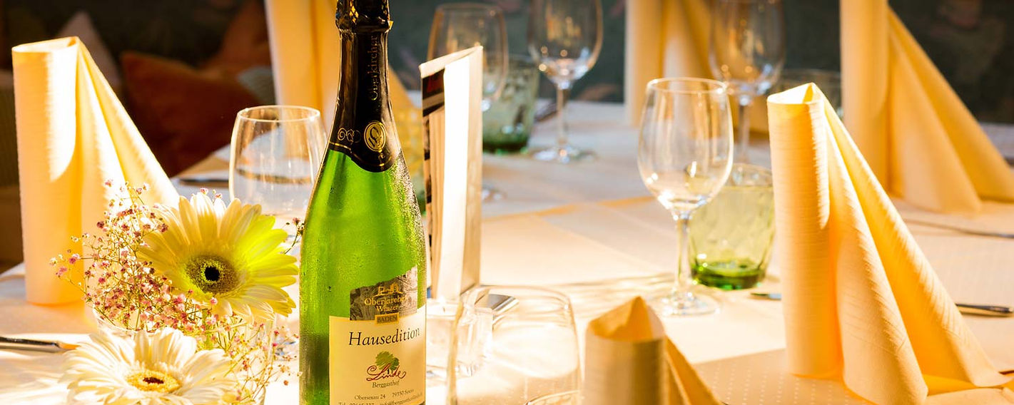 Festlich gedeckter Tisch mit einer Flasche Wein