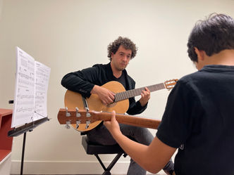 Guitar teacher demonstrating chords to a student during a private guitar lesson at Mermi Music Academy in North Vancouver