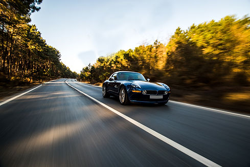 black-luxury-sport-car-driving-accross-forest.jpg