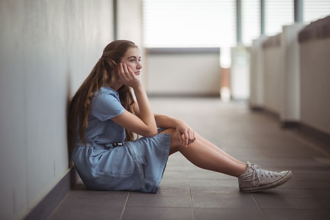 sad-schoolgirl-sitting-corridor.jpg