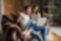 young-smiling-couple-sitting-couch-home-casual-outfit.jpg