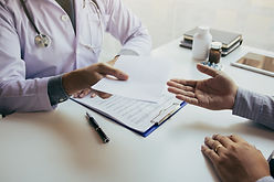 asian-male-doctor-talking-clinic-room-handing-prescription-patient.jpg
