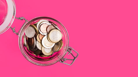 overhead-view-open-glass-jar-with-many-coins-pink-backdrop.jpg