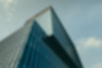 low-angle-view-building-glass-facade-beautiful-cloudy-sky.jpg