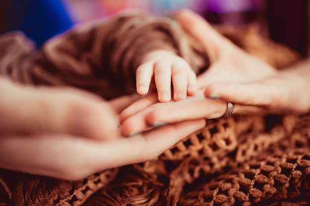 mother-holds-his-palm-little-arm-her-child_1304-4754.webp