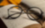 What is a reading journal blog image. Reading glasses on top of a novel