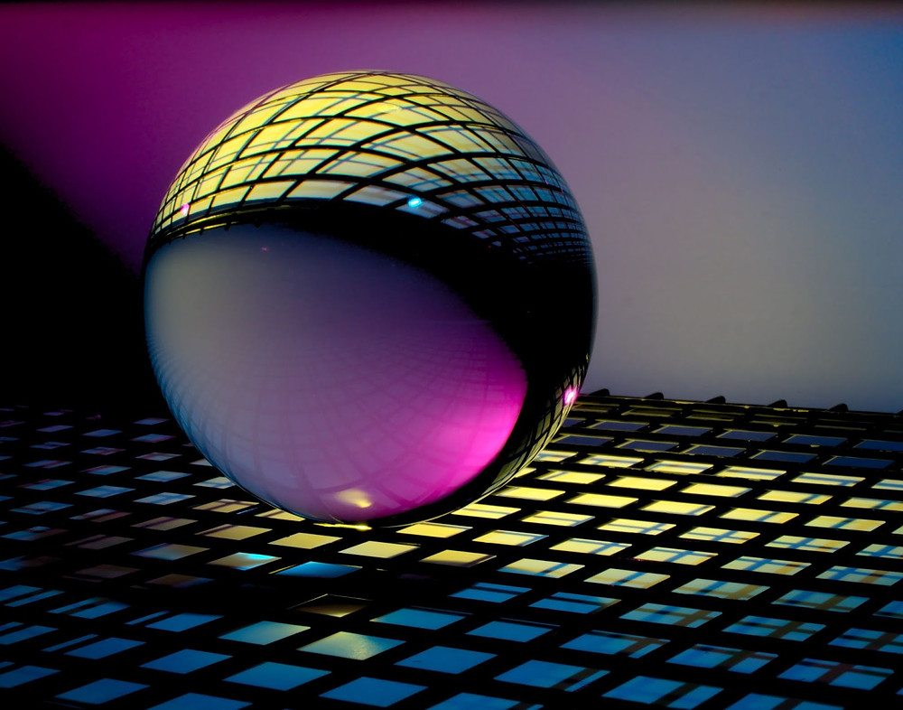 A CGI rendering of a metallic sphere hovering above a gridded floor.
