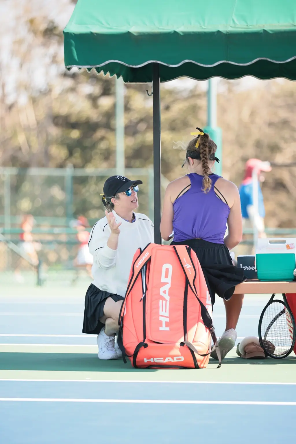 Mariana speaking with a player courtside