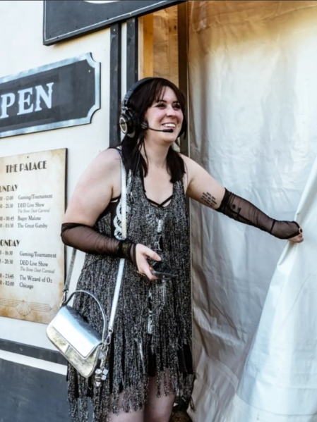 Luci fitzpatrick dressed as a flapper girl for D&D live event, outside a tent, wearing a headset