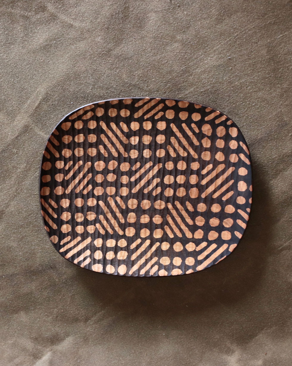 dark brown ebonized wooden plate with whittling mark