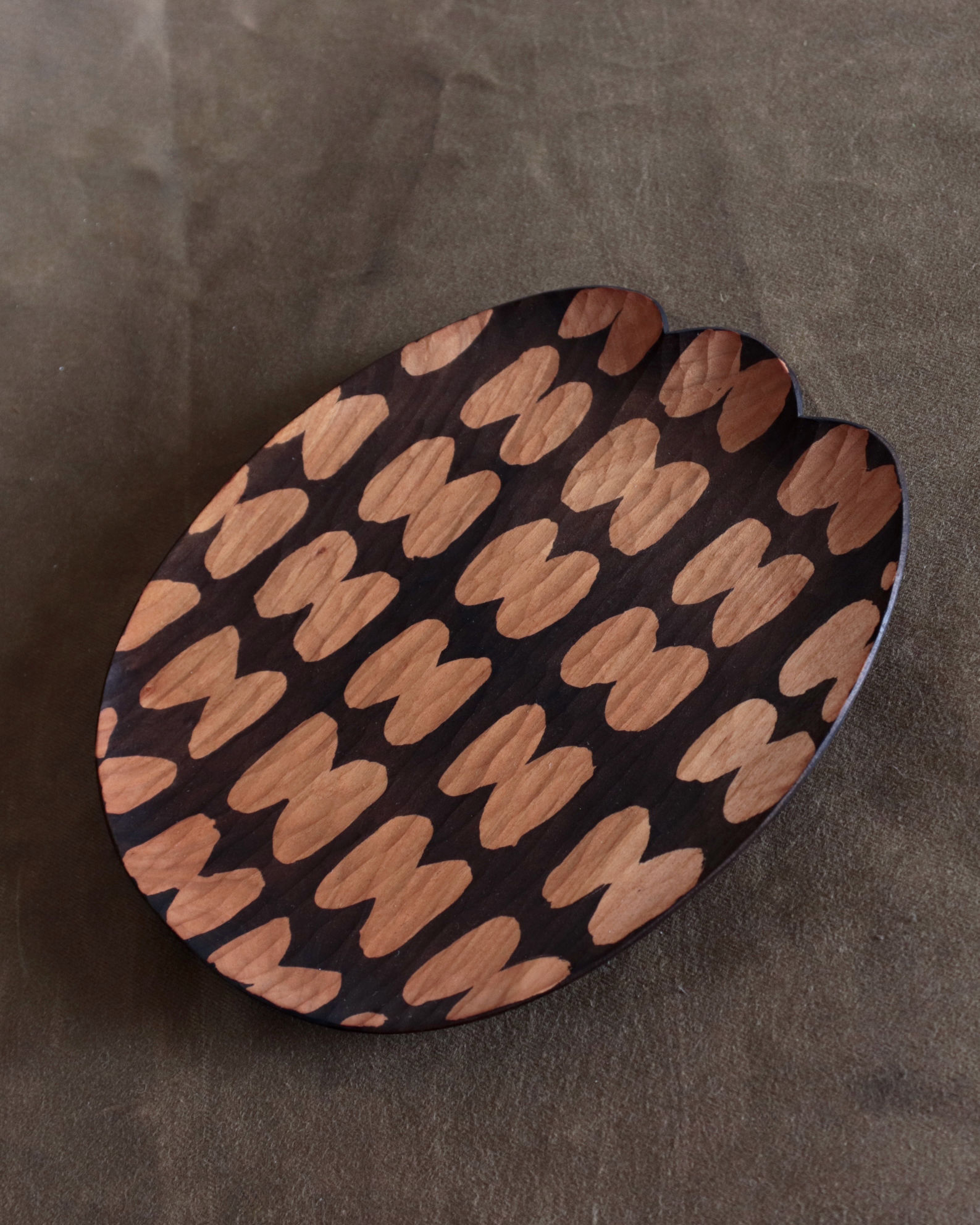 dark brown ebonized wooden plate with whittling mark