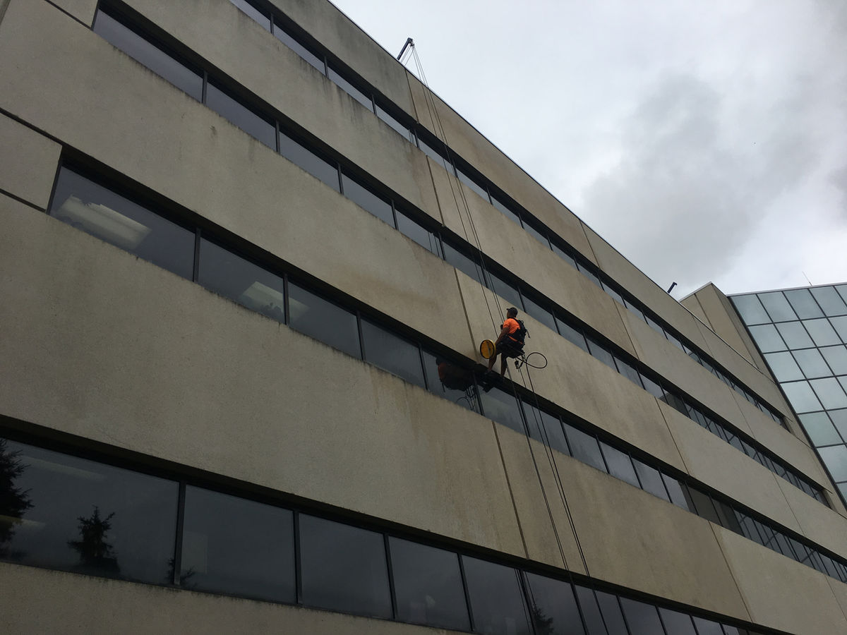 A.K. technician on rope descent cleaning a high-rise office building