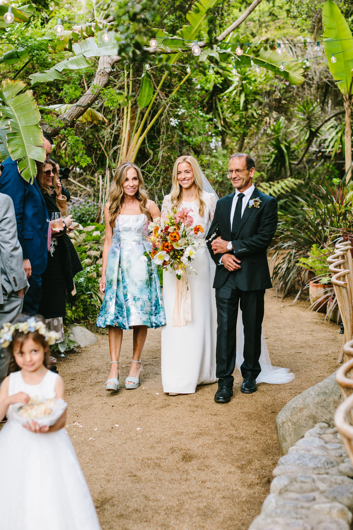 a bride is walking down the aisle with her parents