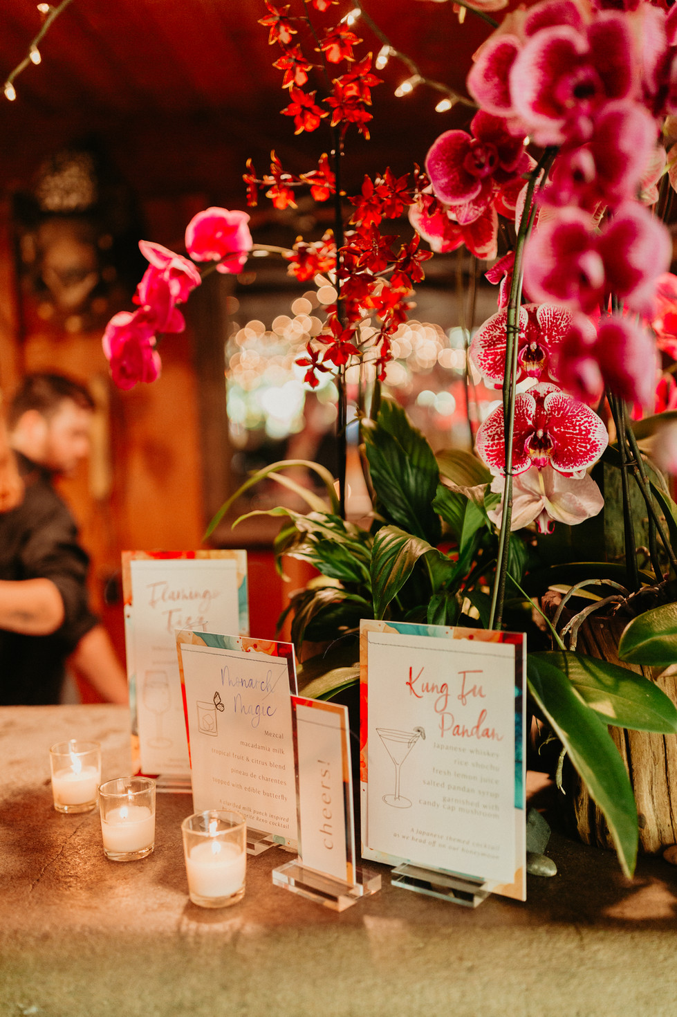 Whimsical bar signage surrounded by soft candlelight and vibrant blooms, perfect for a lively event atmosphere
