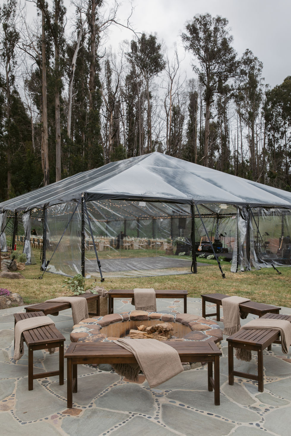 a clear tent with a fire pit in front of it at a wedding in Pescadero