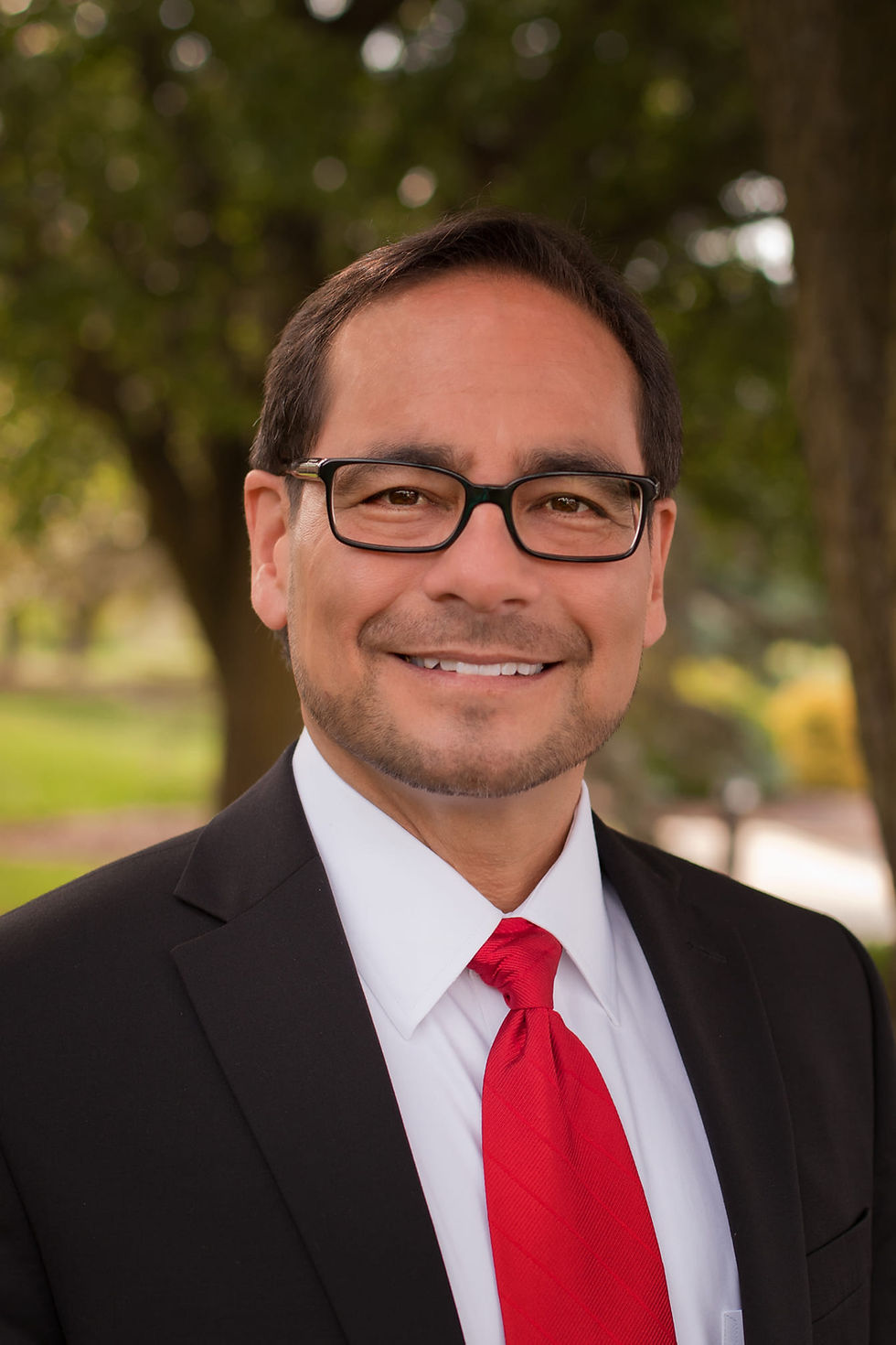 William Smits, M.D. in a suit and red tie