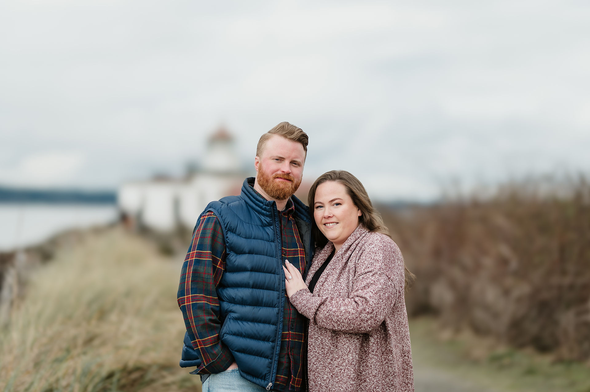 Couple poses in front of lighthouse