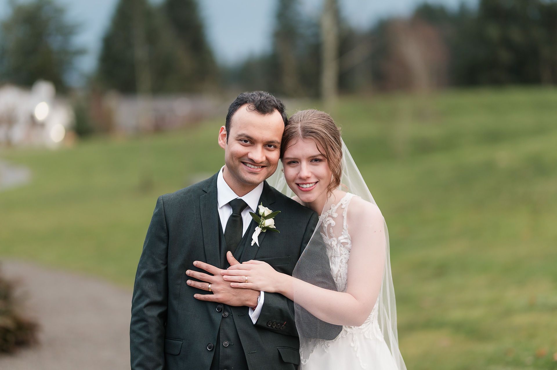 Bride and groom enjoying a romantic moment together in the rain during their wedding at Bellevue Hilton.