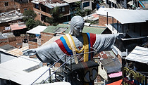 View of Comuna 13 in Medellín with hillside homes and a colorful community landmark.