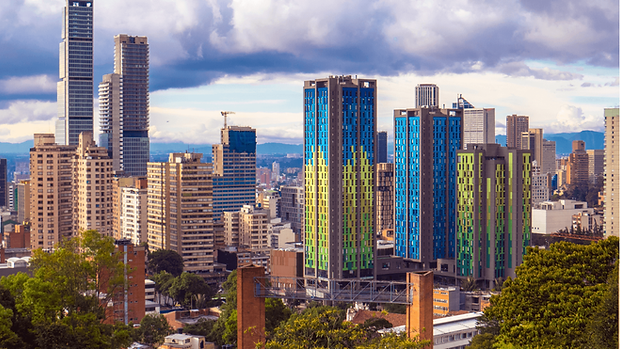 Modern skyline of Bogotá, Colombia with high-rise buildings and mountains in the background.