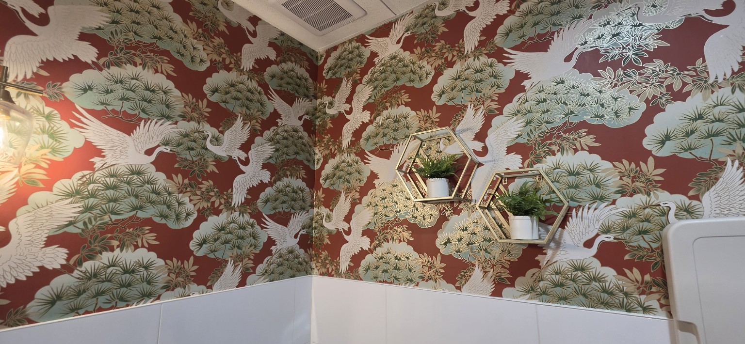 Crane & Botanical Restroom. Rich red botanical and crane wallpaper in a restroom.