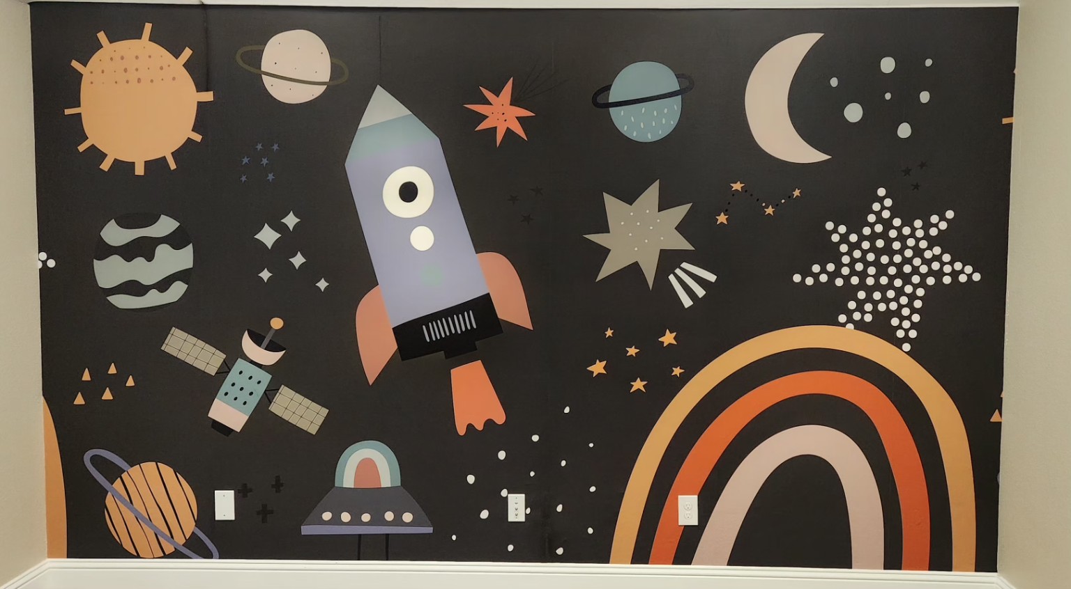 Playful Space Mural. A space-inspired mural with stars, planets and a rocket.