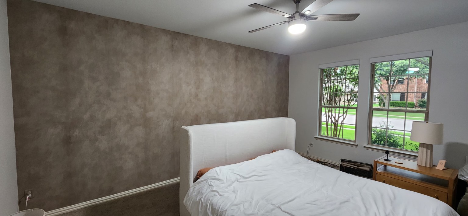 Textured Bedroom Feature Wall. Soft taupe textured feature wallpaper behind a bed.