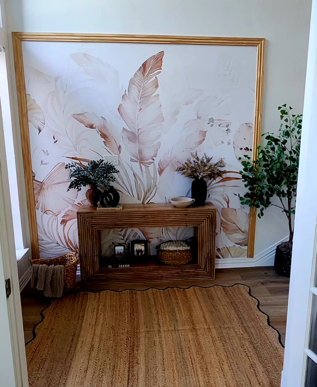 Blush Botanical Mural. Soft, oversized tropical leaves framed as a mural in a residential interior.