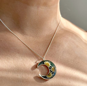 Moon-shaped pendant with daisies