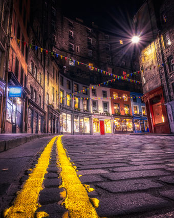 Calle adoquinada nocturna, luces cálidas, Chechu Fotografía