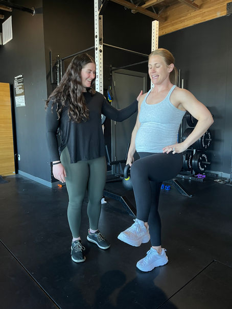 Pelvic floor physical therapist guiding pregnant woman through exercise