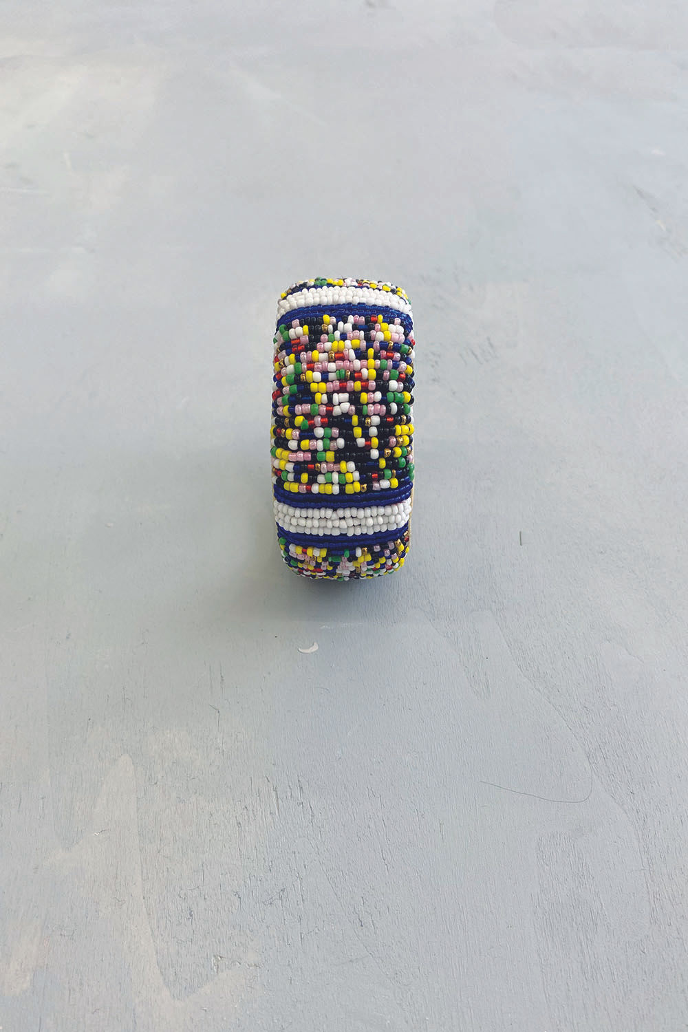 Détail du bracelet épais en cuir et recouvert de perles multicolores