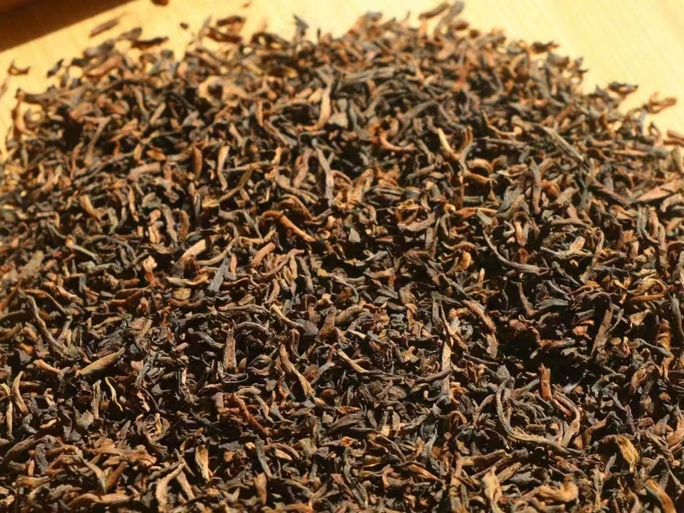 Premium Ripe Pu Erh on a white plate, showing dark brown small tea buds. Premium Ripe Pu Erh product shot. 