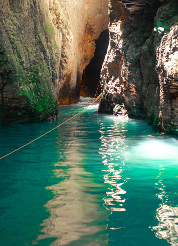 Tourists swimming in the pool at the base of La Leona Waterfall.