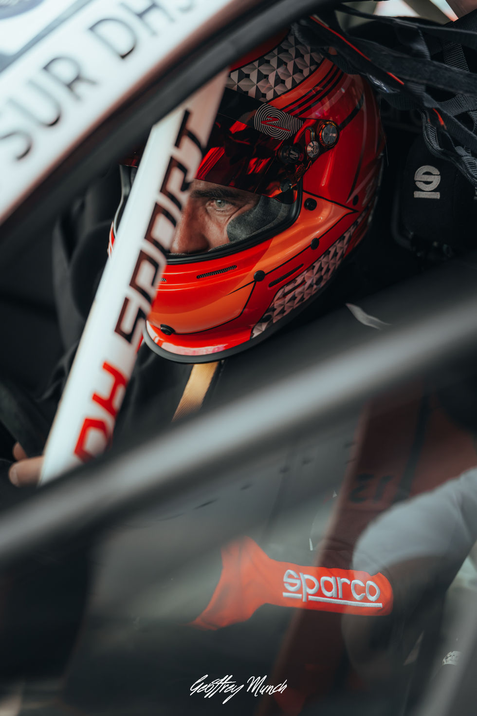 Pilote DH Sport casqué au volant d’une voiture de course sur le circuit de Mirecourt.