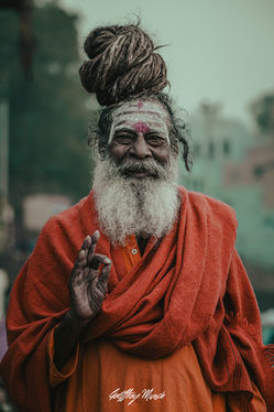 Photographie professionnelle d’un brahmane souriant sur les ghats de Varanasi en Inde, capturant spiritualité, authenticité et émotion.