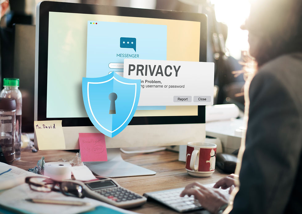 Person typing at a desk, monitor shows privacy alert from messenger app. Shield icon displayed. Sunlit office with coffee mug and notes. Australian Data Privacy Laws