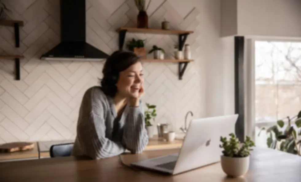Smiling woman in an online counselling session at home, representing calm and supportive telehealth