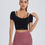 Thumbnail: Woman wearing our black Collarbone Chic Striped Shoulder Top with maroon leggings, hand on shoulder.
