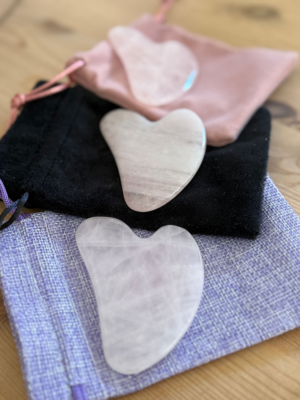 3 Rose quartz crystal Gua Sha in a display