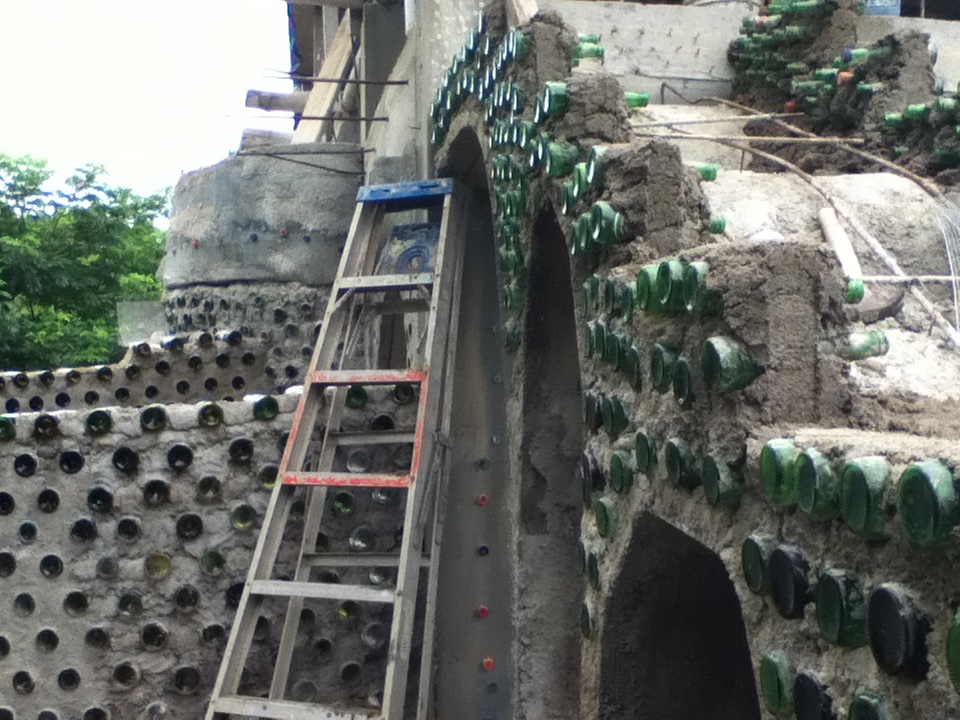 A bottle-brick wall under construction at The Chaos Oasis