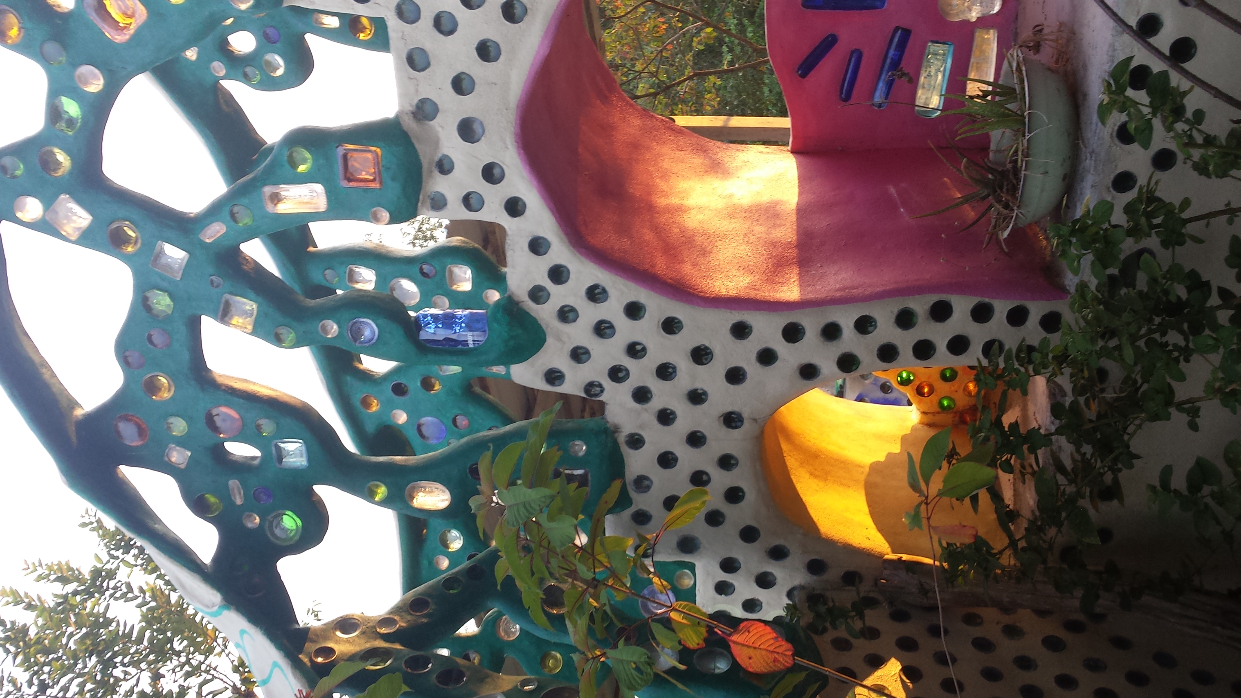 A hand-built wall of the Chaos Oasis Earthship, made from recycled glass bottles and tyres