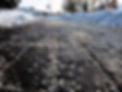 Salt grains on icy sidewalk surface in the winter. Applying salt to keep roads clear and p