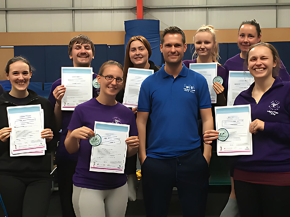 A group of course attendees holding their certificates