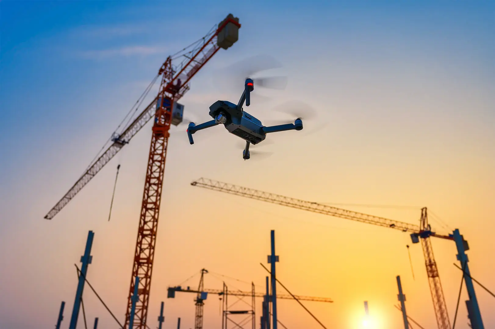Drone flying near construction cranes at active development site, aerial construction photography and progress documentation NYC