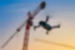 Drone capturing aerial footage of construction cranes at active development site, construction photography NYC and aerial documentation