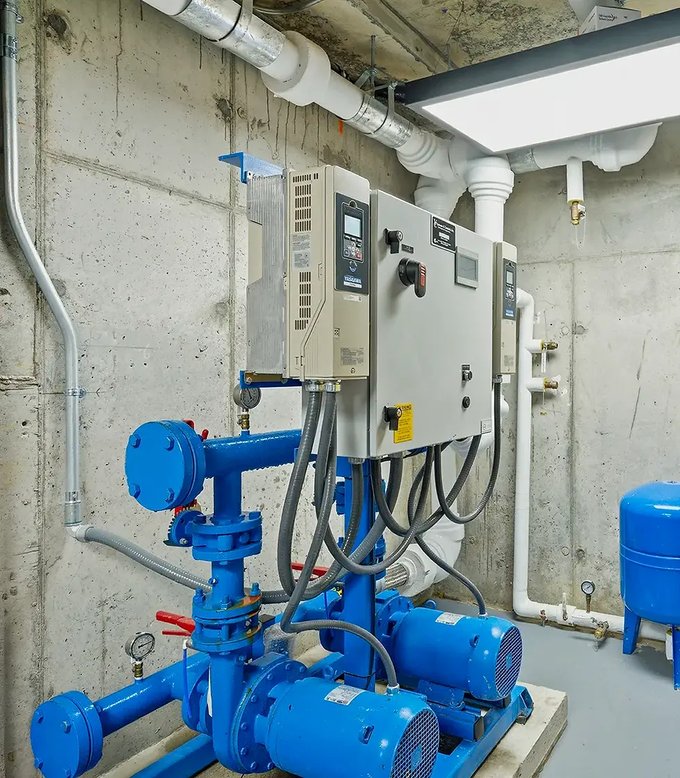 Industrial mechanical room with pumps and control systems, commercial building infrastructure photography NYC