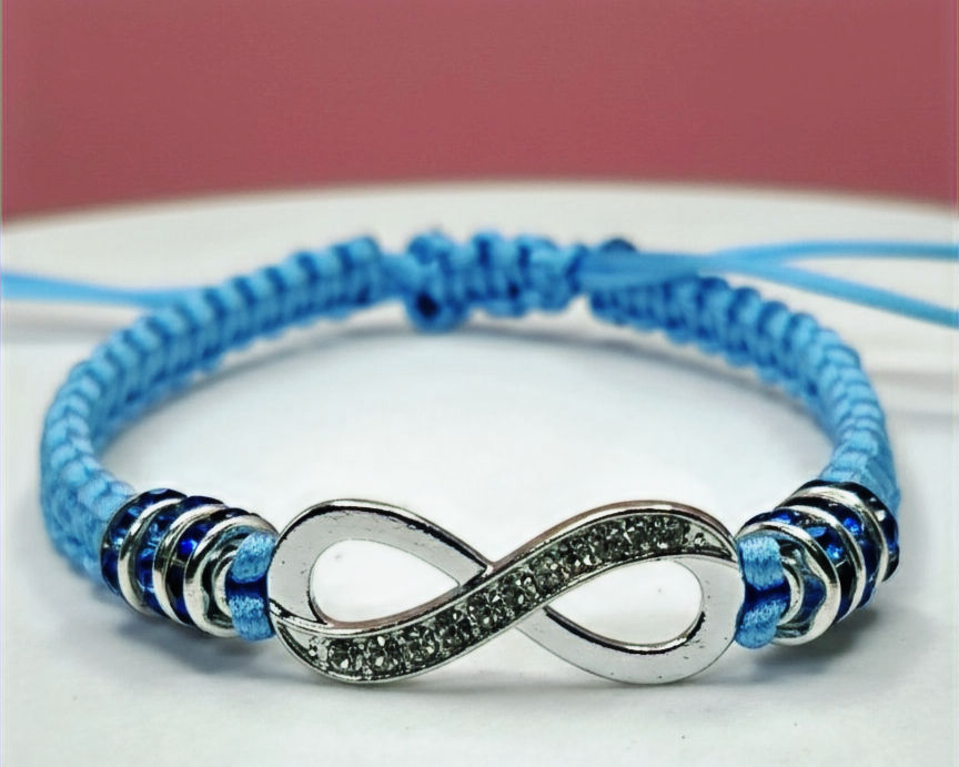 Light blue macrame bracelet featuring a central silver infinity symbol charm with crystal accents