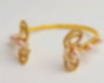 Handcrafted gold wire-wrapped cuff bracelet adorned with delicate pink pearls and crystals.