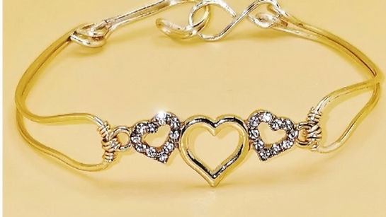 Handcrafted gold-tonned bracelet with a three-heart centerpiece,featuring two crystal-paved hearts.